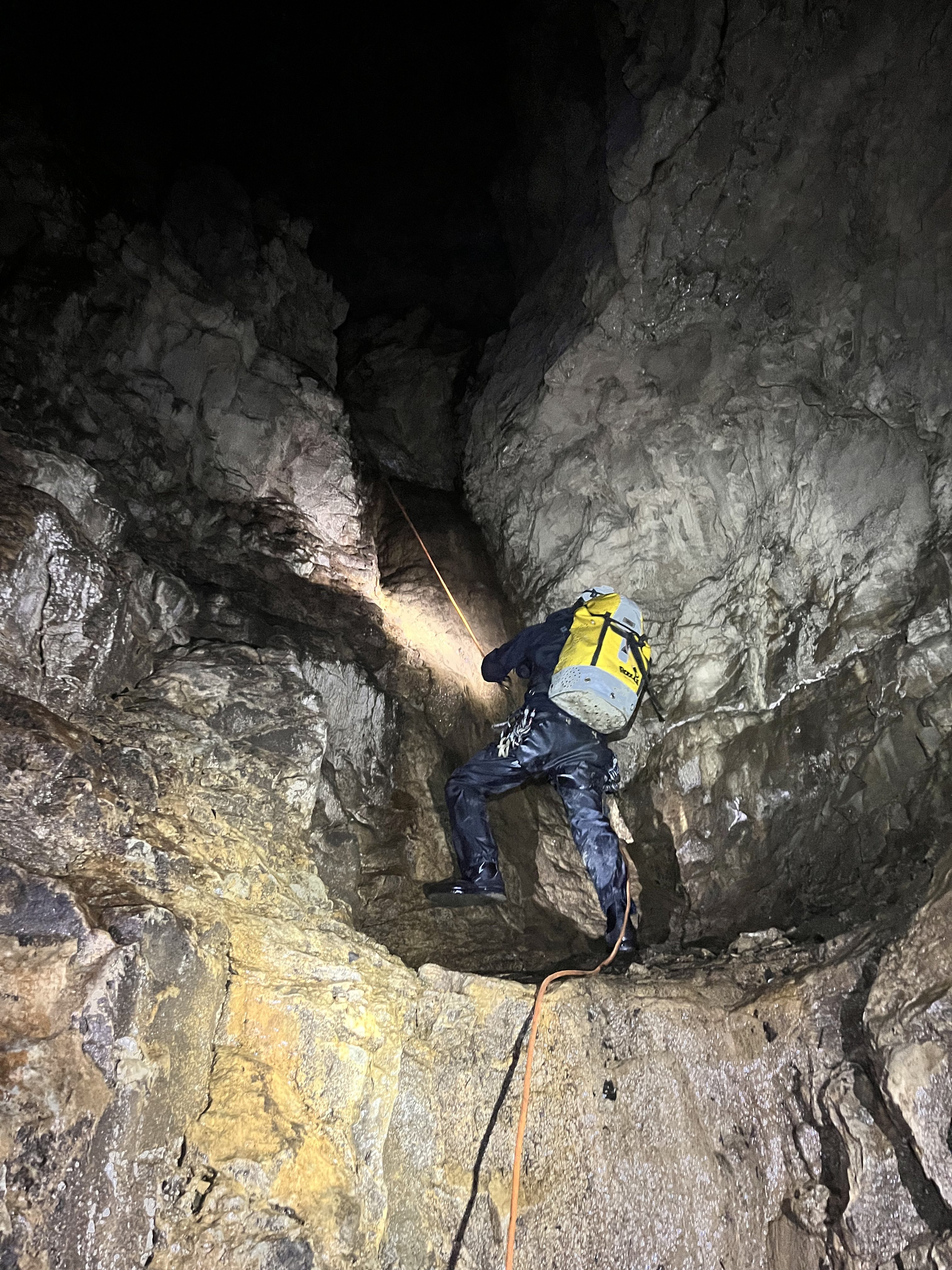A person rappelling down a cave.