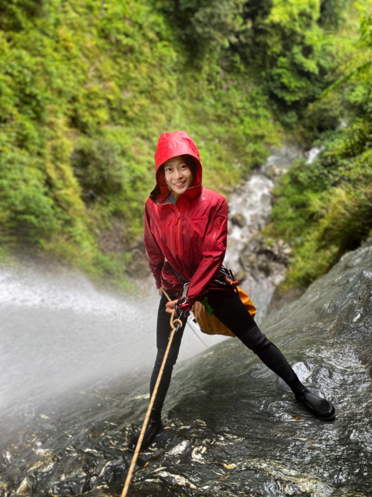 Client enjoying a rappel down a waterfall on a jungle canyoning tour.